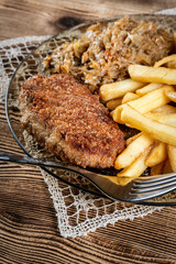 Pork chop in breadcrumbs served with fries and stewed cabbage.