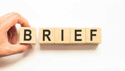 Word brief. Wooden small cubes with letters isolated on white background with copy space available....