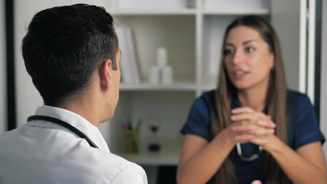 Smiling female professional doctor handshakes male doctor agree to a deal. Happy physician in white uniform shake hand of woman at , medical service trust concept 4k