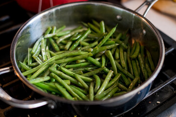 green beans cooking in stainless steel skillet
