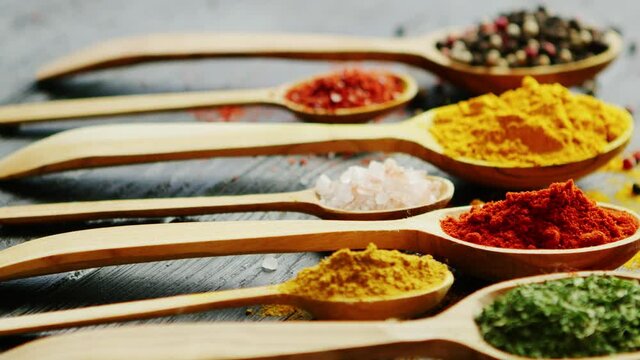 Spoons with assorted spices on a table