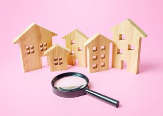 Many wooden figures of houses and a magnifying glass. Search for housing to buy or rent, realtor...