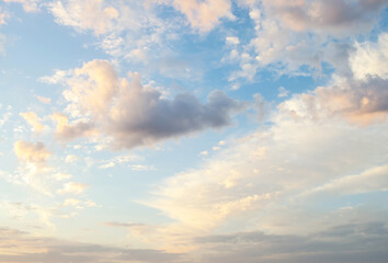 Beautiful view of the morning white clouds in the blue sky. Peach beige color clouds. Homosphere. Sunrise. The concept of feelings of peace and dimension. The beauty of nature elements