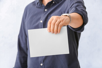 Man with blank paper sheet on white background