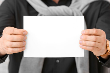 Man with blank paper sheet, closeup