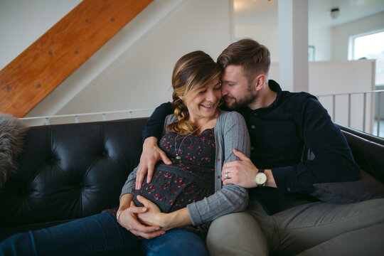 Happy young expecting caucasian couple hanging out at home - cud
