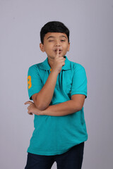 Mischievous Indian boy winking, isolated over white background.