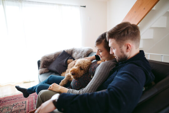 Happy young expecting caucasian couple hanging out at home - cud