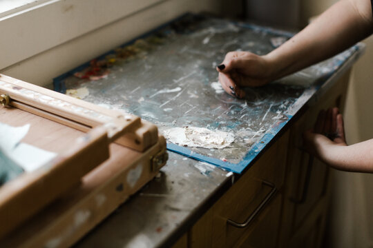 artist scraping old paint off pallette