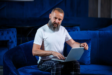 Adult male businessman, teacher, mentor working on a new project. Sits by a large window on the...