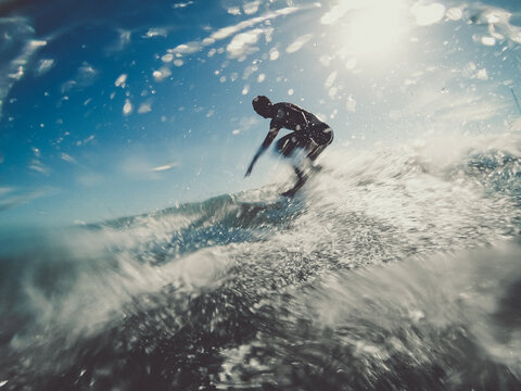 unrecognisable surfer riding wave - blue skye