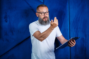 Adult male mentor, director, businessman in glasses and a suit studying documents while sitting at the table. Working day concept