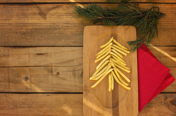 Fast food Christmas on wooden table. Cristmas tree potatoes fries. French fries shape Cristmas tree.  Flat lay