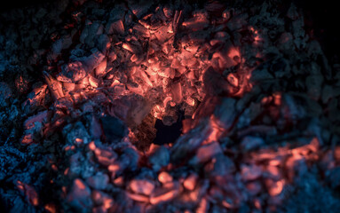 Burning embers of the fireplace after the fire. Glowing incandescent embers texture. close up.