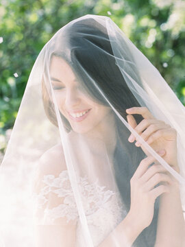 Girl in a blooming garden in a wedding veil