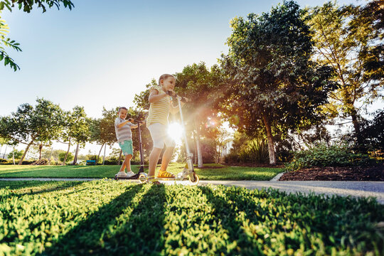 Children playing on scooters in park