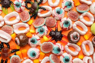 Tasty treats for Halloween on color background