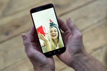 Christmas online congratulations. Christmas online meet. Christmas wishes  on smartphone, copy space. Chatting, man's hands hold a phone