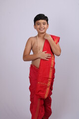 cute Indian boy in ethnic wear sovla and uparna - dhoti and stole. holding his stole.