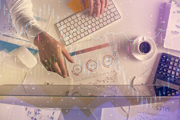 Multi exposure of man's hands typing over computer keyboard and forex graph hologram drawing. Top view. Financial markets concept.