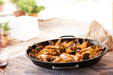 Homemade seafood paella on the table ready to serve on a terrace