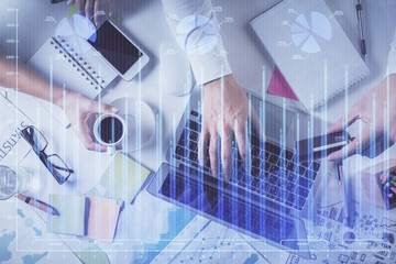 Multi exposure of man's hands typing over computer keyboard and forex graph hologram drawing. Top...