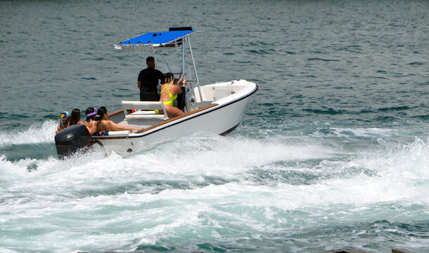 








































Five women and one man enjoying a high speed cruise in an open sport fishing boat.

