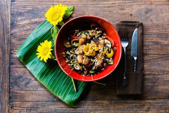 A bowl of rice with grilled fish and mango sauce on top
