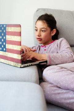 LIttle girl using her laptop at home