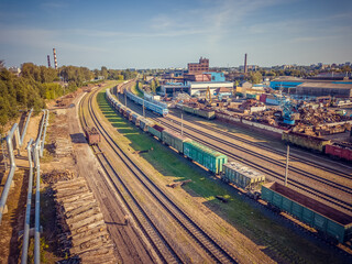 Fototapeta na wymiar Industrial scene with trains, railway platform, Metalworking plant, top view from a drone. Freight train. The carriages of goods by rail. Heavy industry.