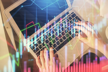 Double exposure of woman hands working on computer and forex chart hologram drawing. Top View....