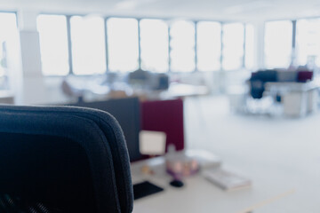 row of chairs in a room. large office with windows. blurred indoors