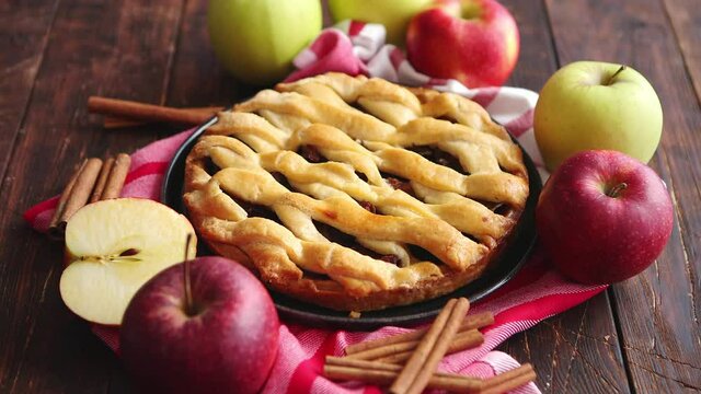 Homemade pastry apple pie with bakery products on dark wooden kitchen table