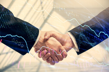 Double exposure of forex graph hologram and handshake of two men. Stock market concept.
