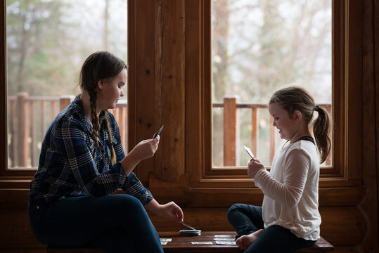 Girls Playing Cards Indoors on Quiet Afternoon At Winter Ski Chalet