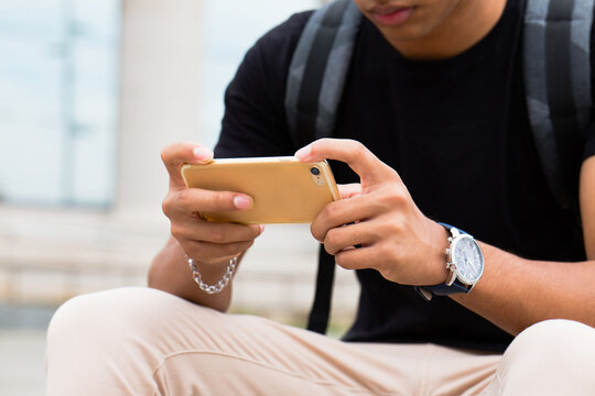 Man using smartphone in a bright location.