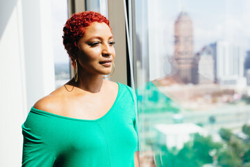 Black Woman looking out window thinking and reflecting at home