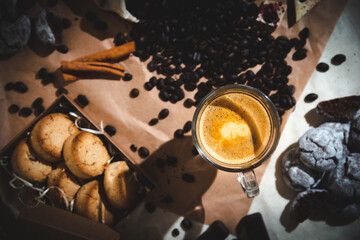 coffee composition with a glass of coffee and sweets on a rustic background close up