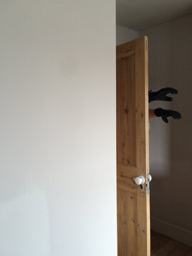 Hands appearing behind door
