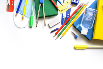 Back to school with colorful supplies, medical face mask and sanitizer on a white background with...