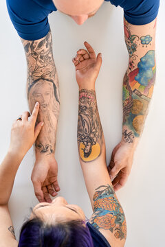 Hipster couple comparing tattoos