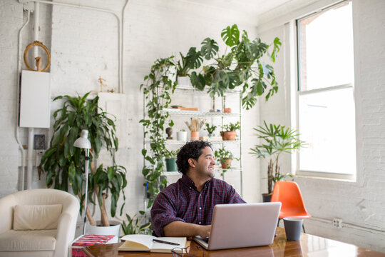 Young man on his laptop in his loft apartment