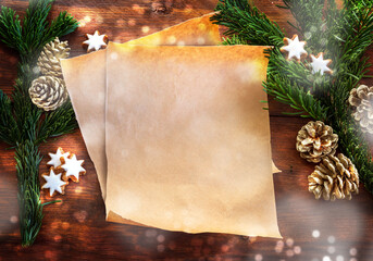Blank paper sheet between fir branches, cinnamon stars and Christmas decoration on rustic dark...