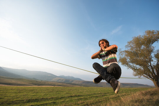 Male slackliner practicing mindfulness meditation outdoor