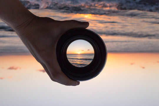 View through spyglass lens to the sun above the sea