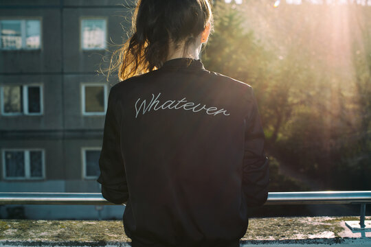 Young Female Rebel Wearing Bomber Jacket With the Word Whatever on Back