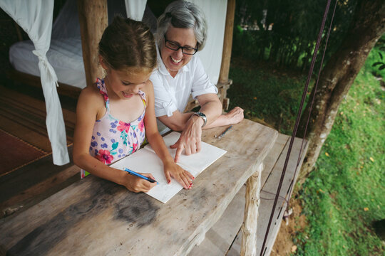 Content grandma and grandchild learning together on tropical hol
