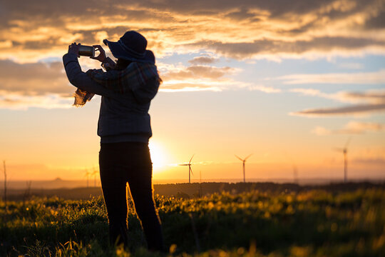 Woman at sunset with windmill on background
