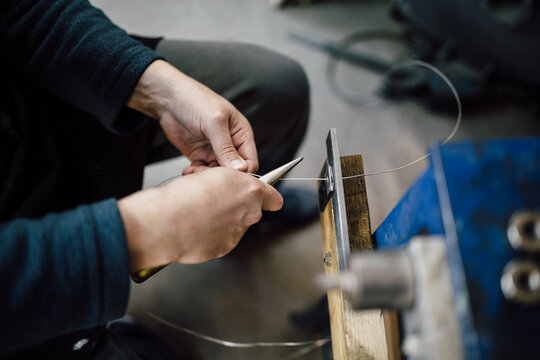 Close up of a man thinning out wire with pliers
