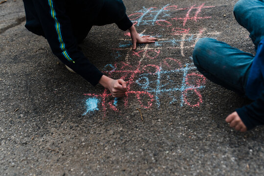 boys playing tic-tac-toe on the drive way